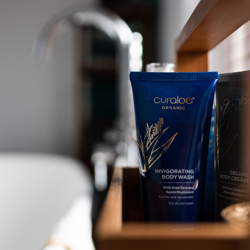 Curaloe Organic Invigorating Body Wash on a bathroom counter with blurred background
