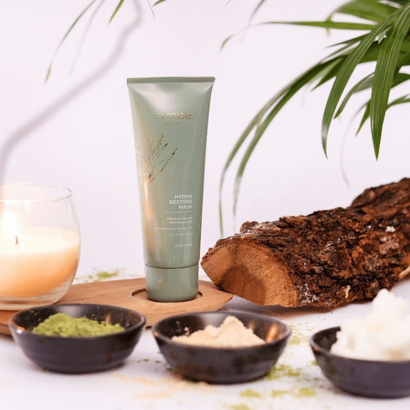 Curaloe Hydra Restore Mask with natural ingredients and decor on a table