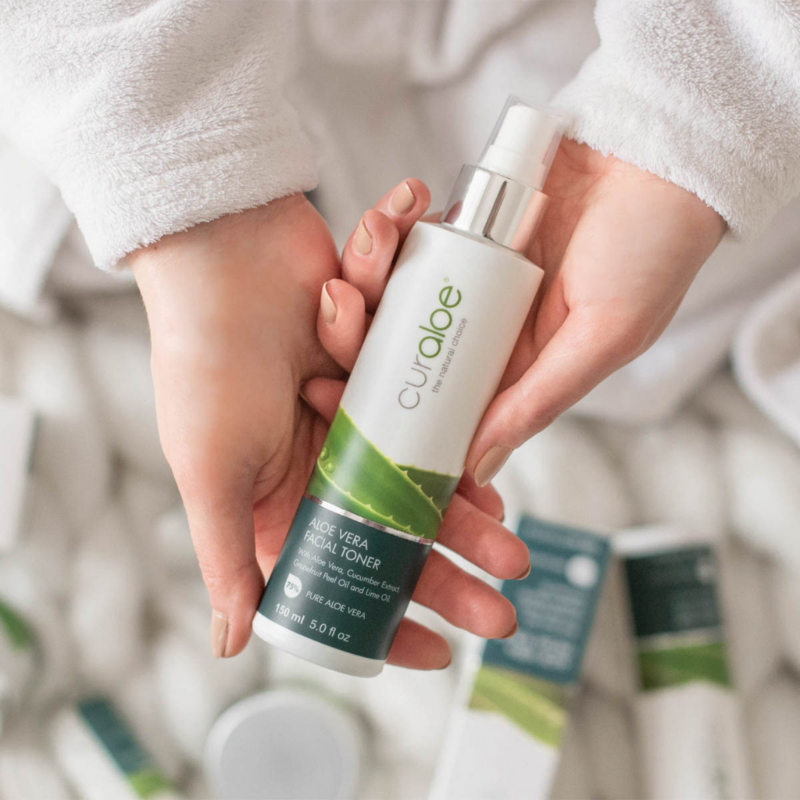 Person holding a Curaloe Toner with a blurred background