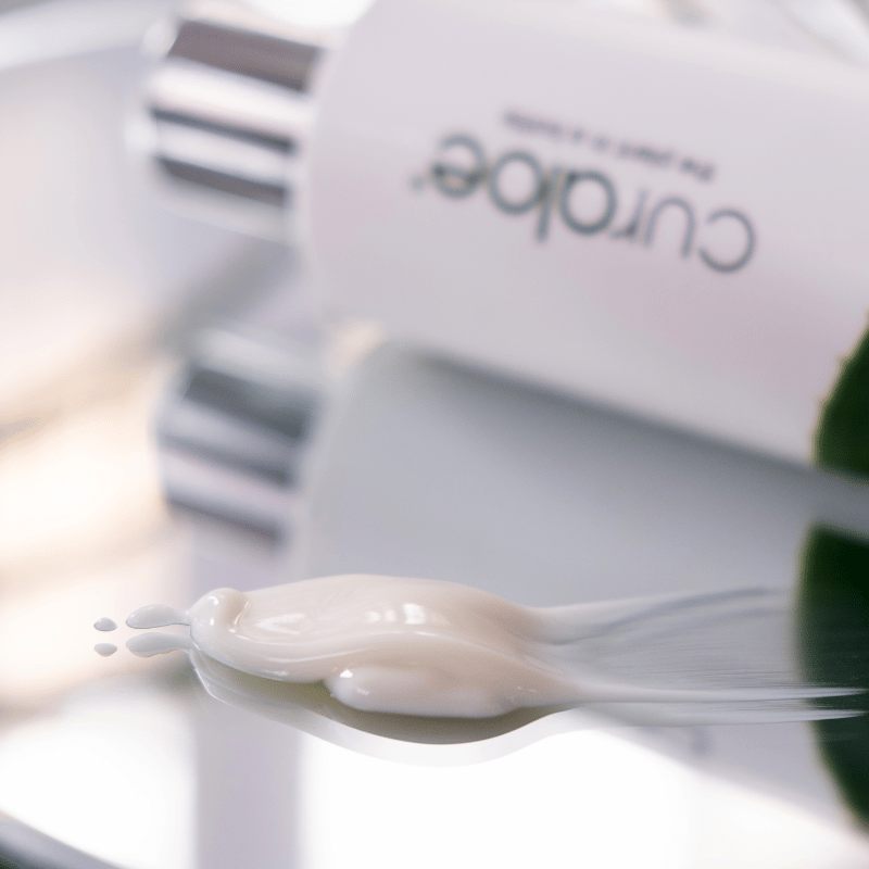Curaleaf product with a spoonful of white cream on a blurred background