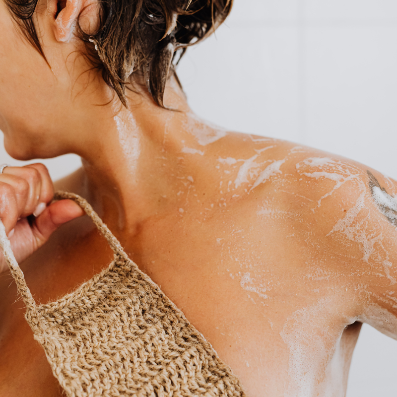 Person showering with soap suds on a white background